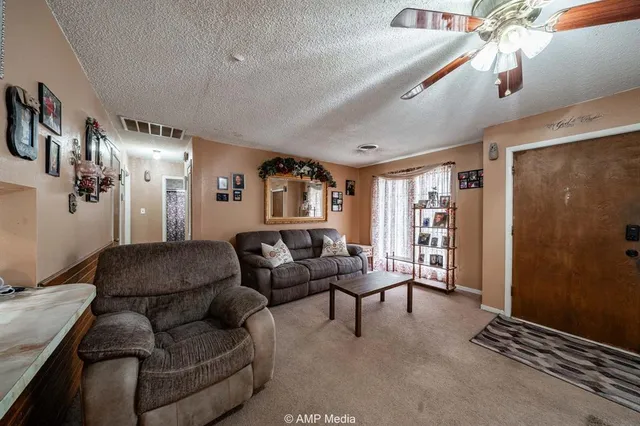 a living room with furniture kitchen view and a window