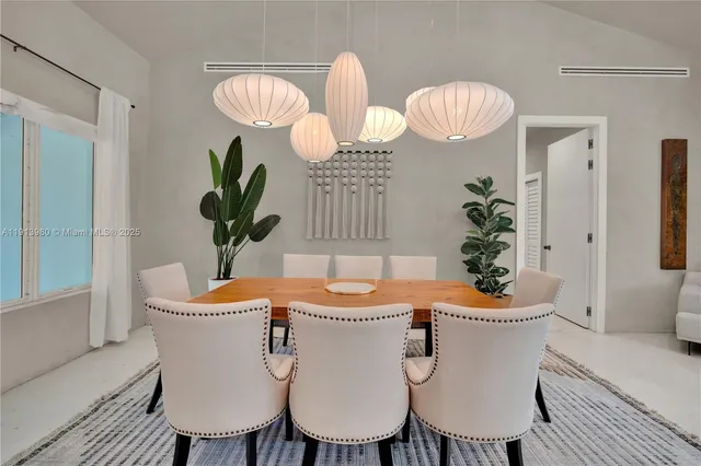 a dining room with furniture potted plants and wooden floor