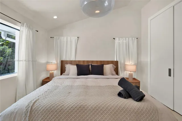 a bedroom with a bed and a large window