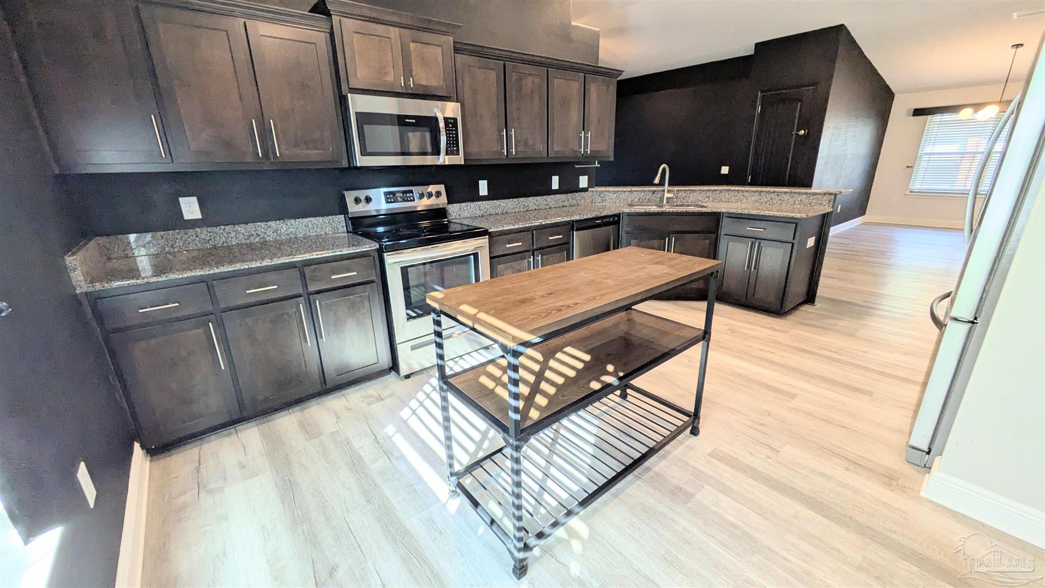 4417 Fiske Street Pace, FL 32571 - Photo 11 of 38 a kitchen with stainless steel appliances granite countertop a stove a sink a microwave a refrigerator and cabinets