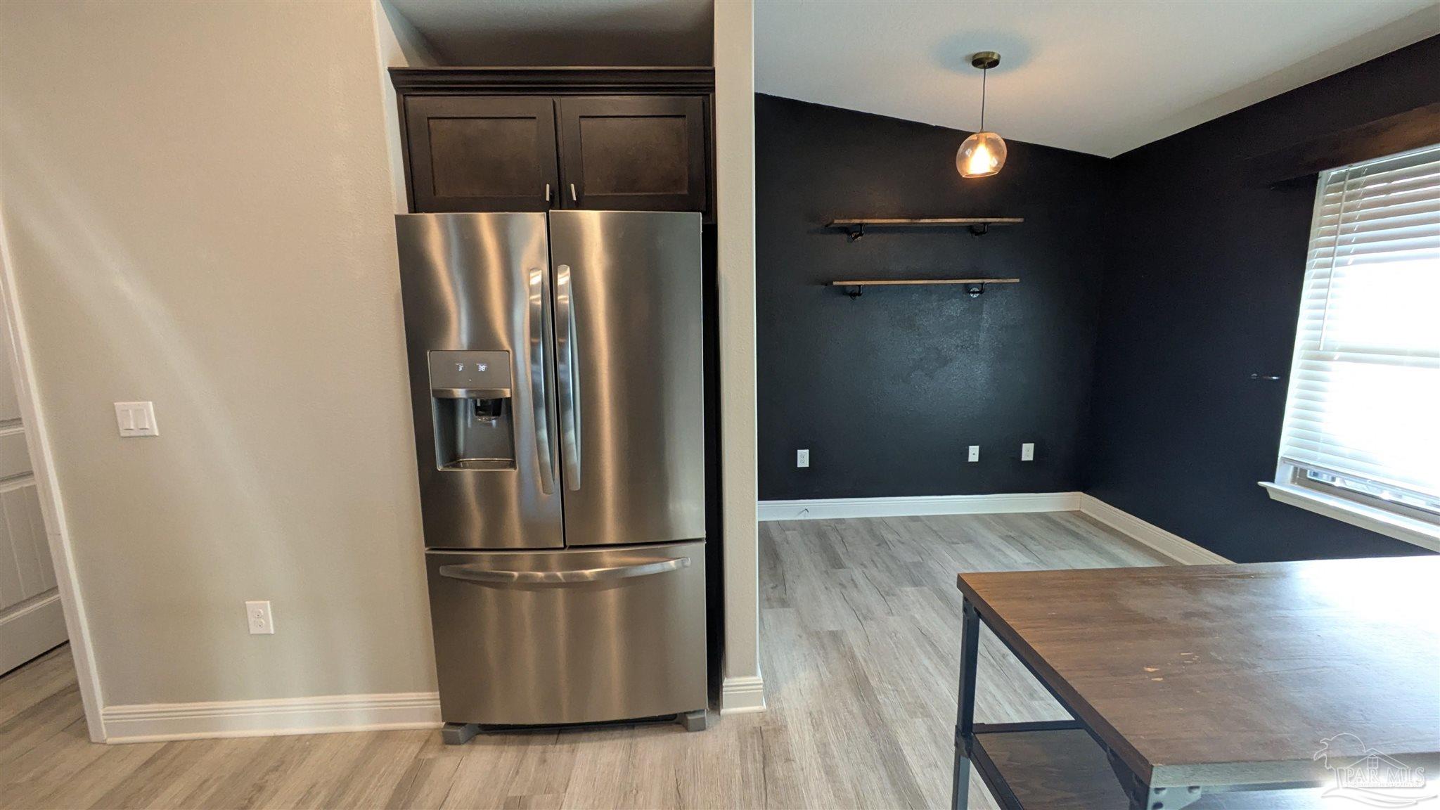 4417 Fiske Street Pace, FL 32571 - Photo 12 of 38 a kitchen with a refrigerator and a wooden floor