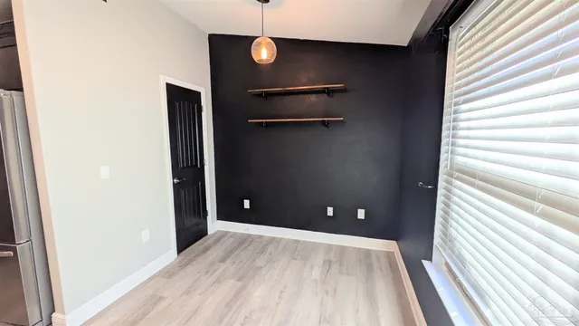 a view of empty room with wooden floor