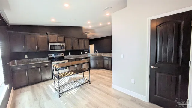 a kitchen with stainless steel appliances a refrigerator and a stove top oven