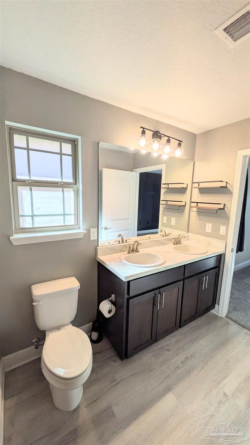 4417 Fiske Street Pace, FL 32571 - Photo 22 of 38 a bathroom with a toilet sink and mirror