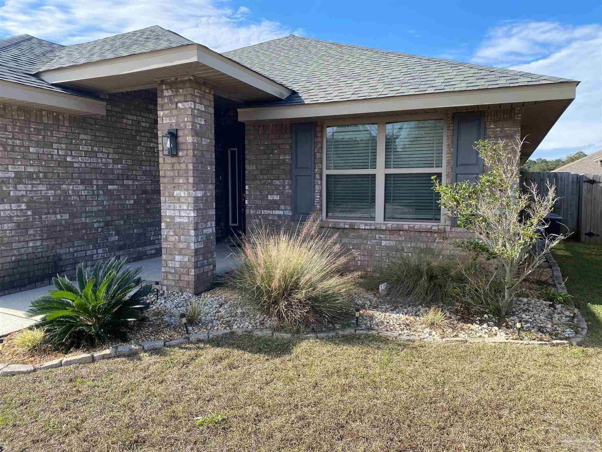 4417 Fiske Street Pace, FL 32571 - Photo 3 of 38 a front view of a house with a yard
