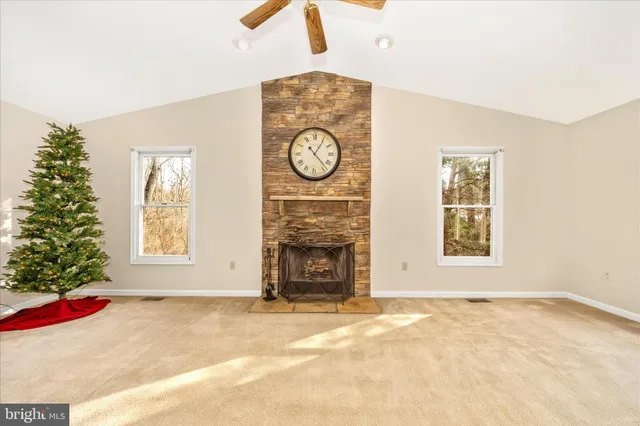 an empty room with windows and fireplace