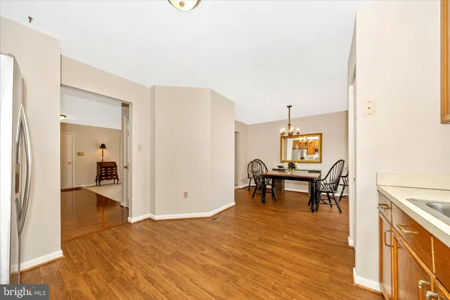 a kitchen with wooden floors and white cabinets