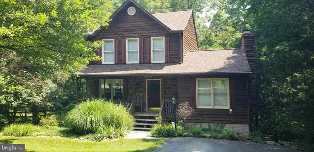 an aerial view of a houses with a yard and lake view