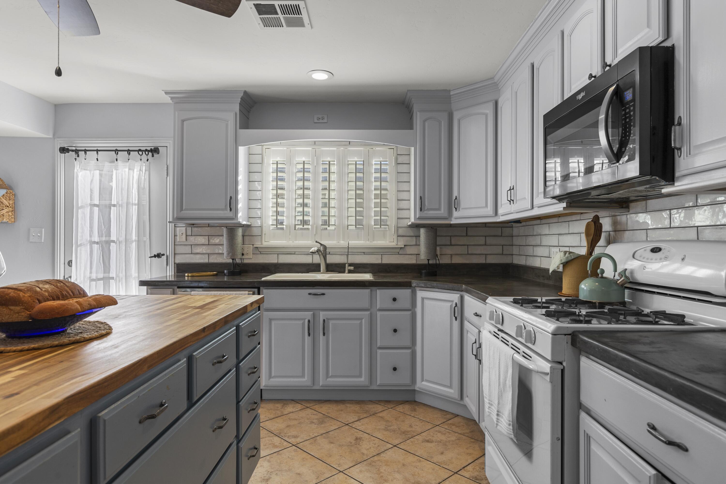 801 Beech Street Tehachapi, CA 93561 - Photo 11 of 24 a kitchen with stainless steel appliances sink stove microwave and cabinets