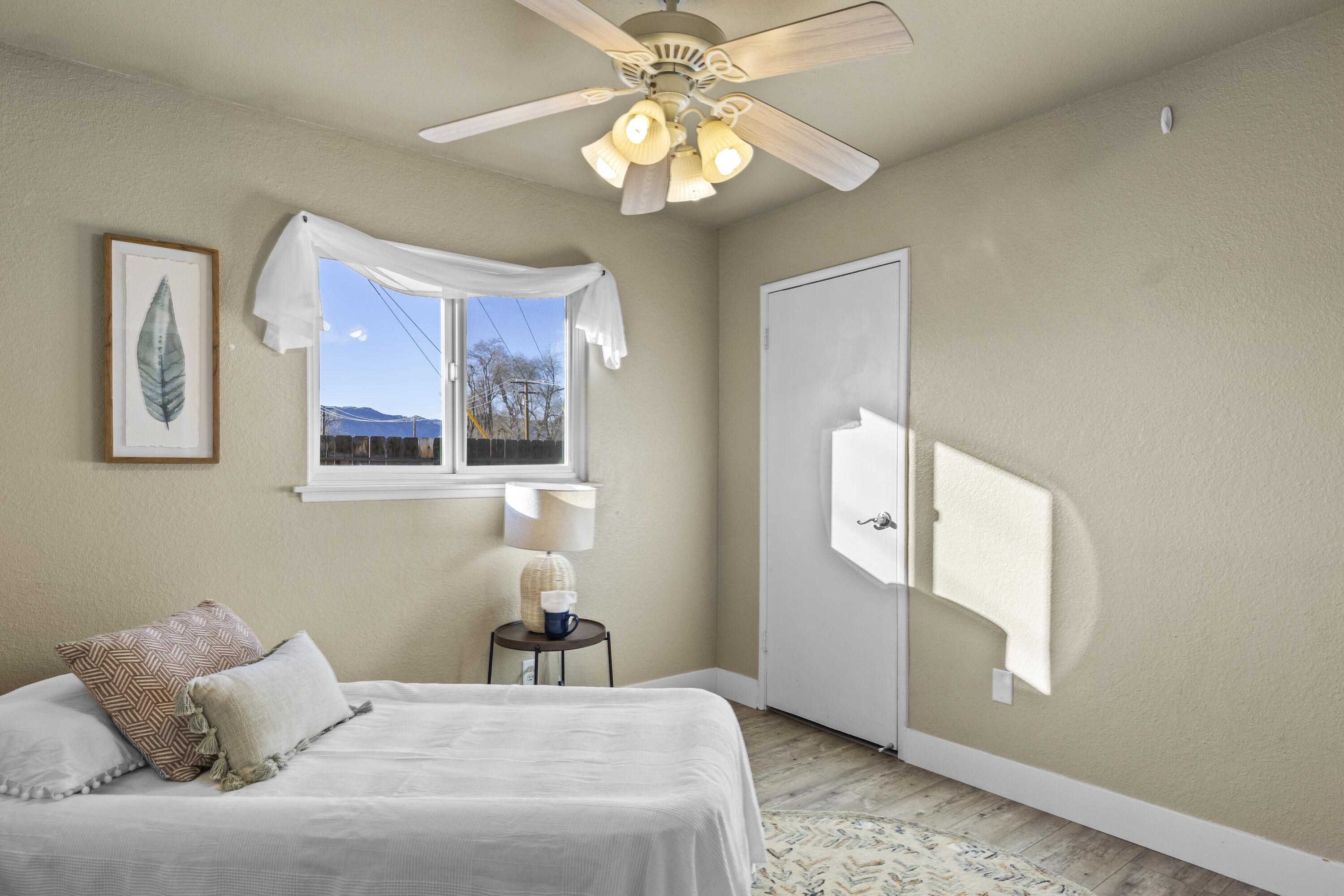 801 Beech Street Tehachapi, CA 93561 - Photo 17 of 24 a bedroom with a bed and a chandelier