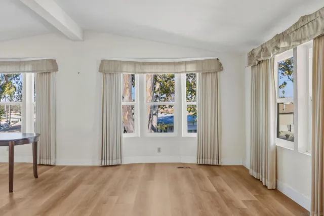 a view of a hallway with wooden floor and furniture