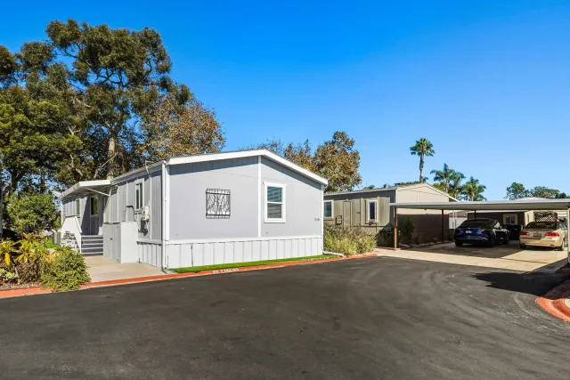 an aerial view of residential houses with outdoor space and ocean view