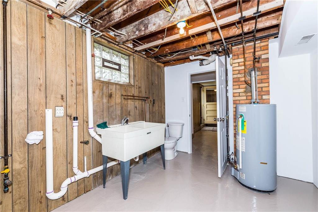 500 Friel Road Baden, PA 15005 - Photo 22 of 24 Massive finished basement includes a separate, large laundry room with double-sinks, working toilet, counter space to fold clothes and storage cabinets. (Water heater pictured.)