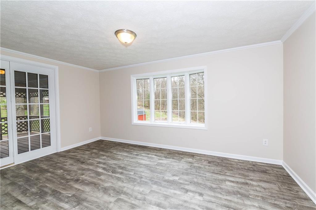 500 Friel Road Baden, PA 15005 - Photo 9 of 24 Dining room with a view to the covered deck and the gorgeous bay window, from which you can see mature trees and green space. Shed is also pictured to the left.