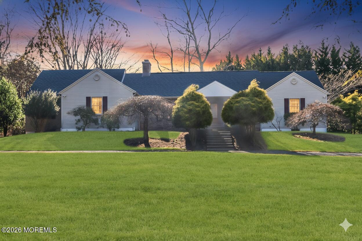a view of a house with a big yard and large trees