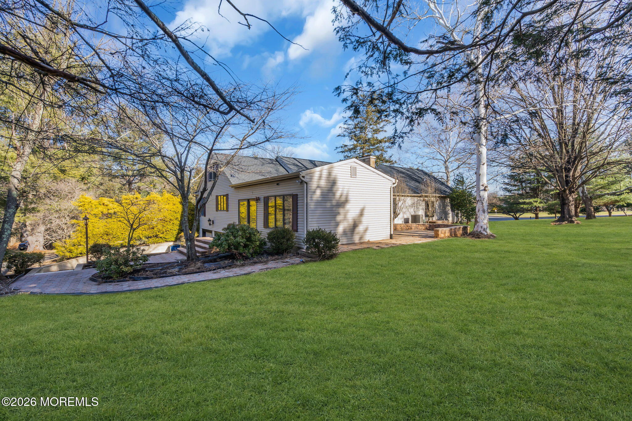 53 Montrose Road Colts Neck, NJ 07722 - Photo 39 of 43 a view of a white house next to a yard with large trees