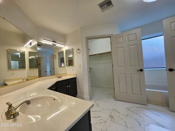a spacious bathroom with a tub sink and mirror