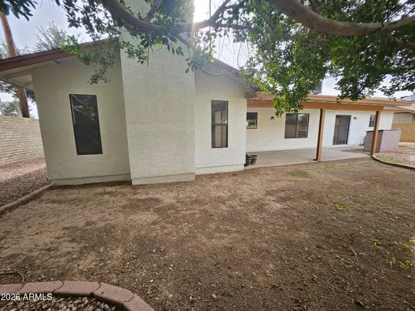 a view of a backyard with table and chairs and wooden fence