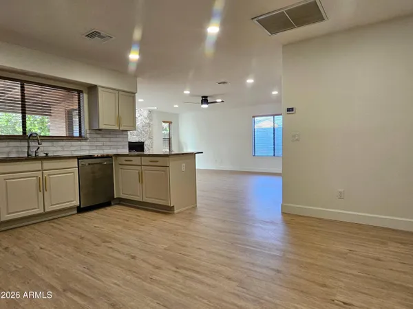 a large kitchen with stainless steel appliances granite countertop a sink and cabinets