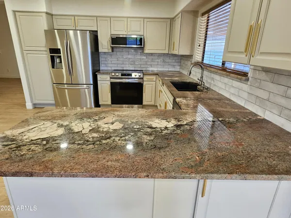 a kitchen with granite countertop a refrigerator and a stove