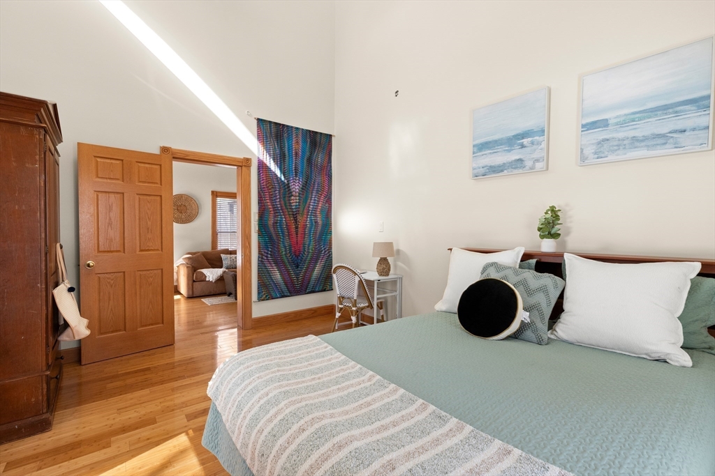 25 Pleasant Street Nahant, MA 01908 - Photo 17 of 39 a bedroom with a bed and a chandelier