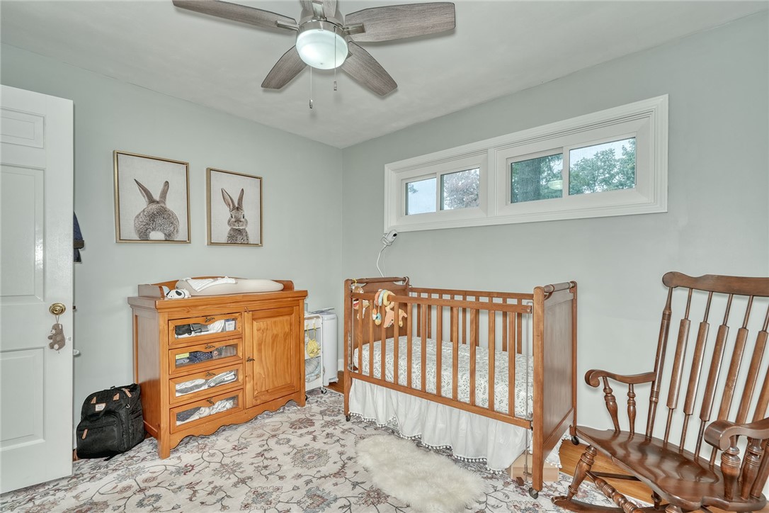 255 Fairport Road East Rochester, NY 14445 - Photo 11 of 26 A quiet bedroom features polished hardwood flooring and elevated horizontal windows welcoming natural light.