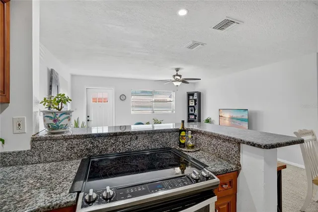 a kitchen with granite countertop a stove and cabinets