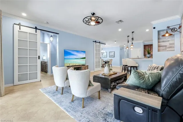 a living room with furniture a flat screen tv and a table