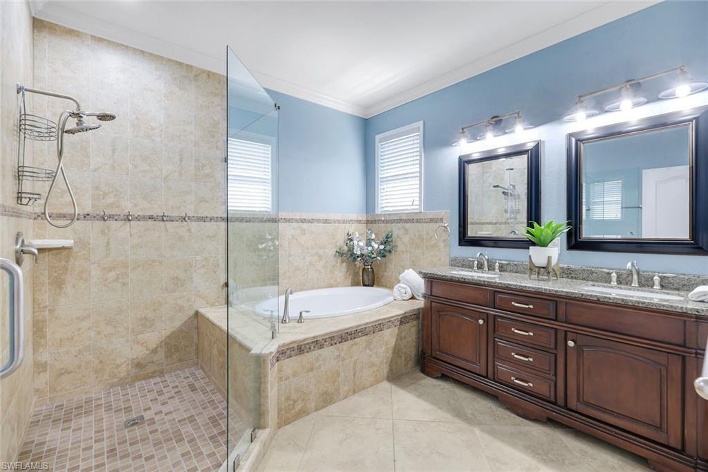 3783 Treasure Cove Circle Naples, FL 34114 - Photo 21 of 43 a bathroom with a bathtub a double vanity sink and mirror