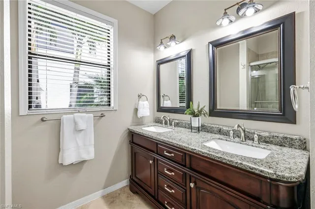 a bathroom with a granite countertop sink vanity and mirror