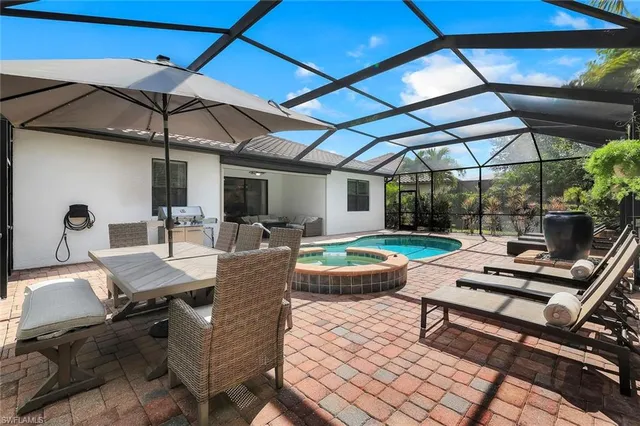a view of a patio with a dining table and chairs under an umbrella