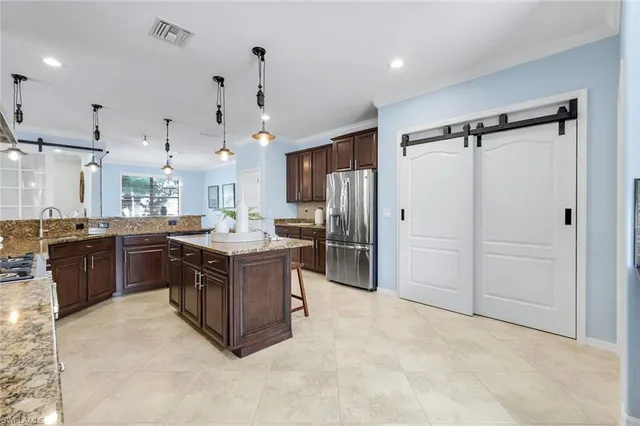 a kitchen with stainless steel appliances granite countertop a stove a sink a refrigerator and a oven