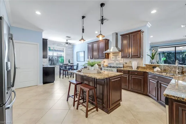 a kitchen with kitchen island granite countertop a sink a counter top space appliances and cabinets