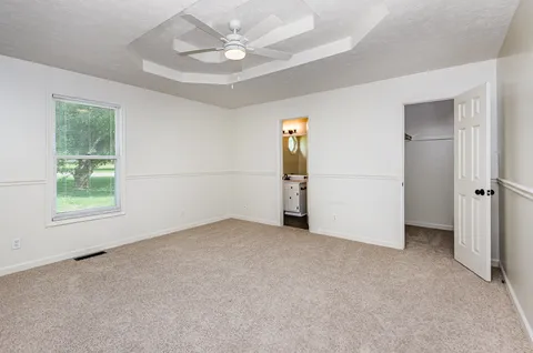 an empty room with a window and a refrigerator