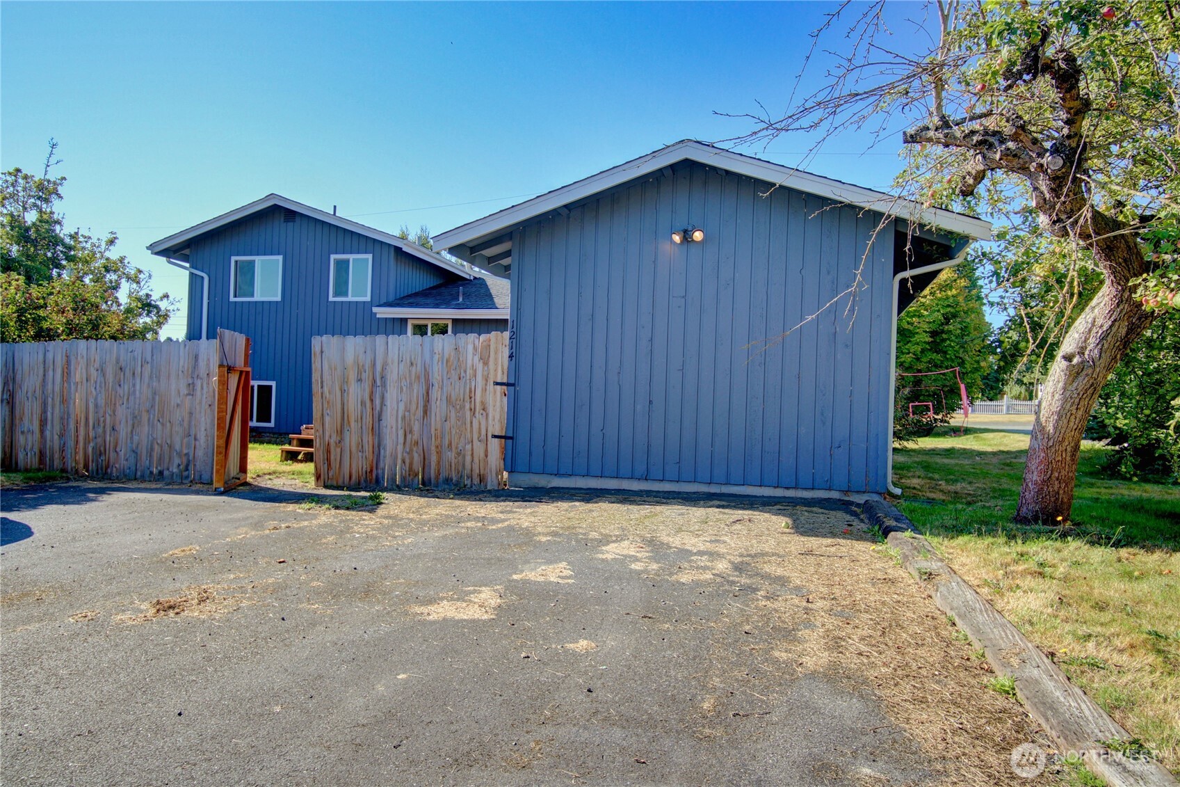 1214 36th Street Anacortes, WA 98221 - Photo 32 of 35 a view of a house with wooden fence and a yard