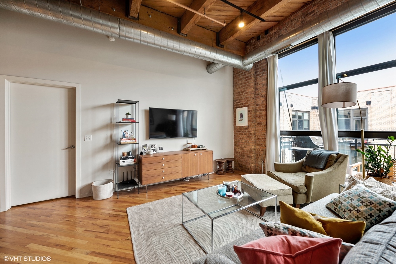 1040 West Adams Street, Unit 428 Chicago, IL 60607 - Photo 13 of 28 a living room with furniture and a flat screen tv
