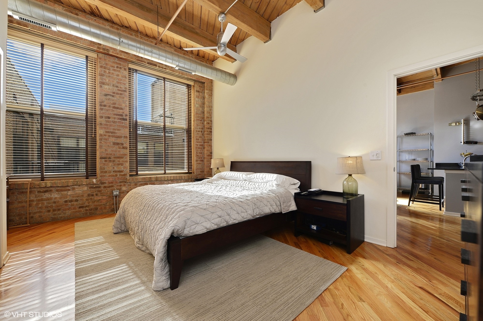 1040 West Adams Street, Unit 428 Chicago, IL 60607 - Photo 18 of 28 a bed sitting in a spacious bedroom next to a window