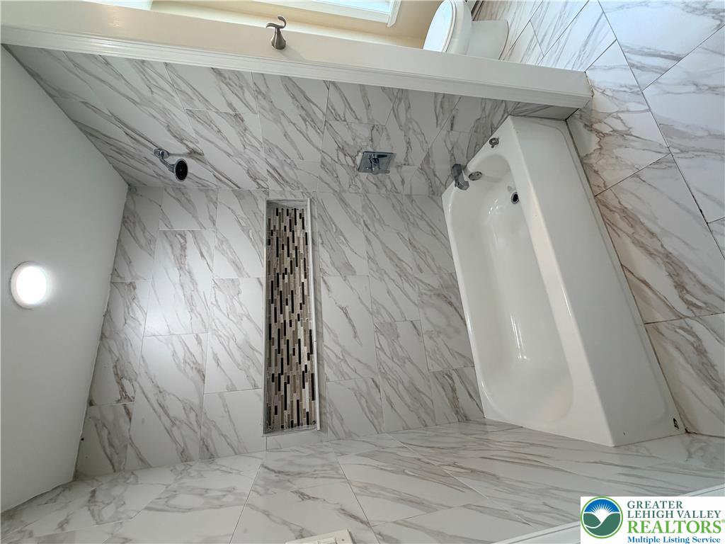 718 Ferry Street Easton, PA 18042 - Photo 21 of 37 Luxurious bathroom with sleek marble-look tiling throughout and a spacious soaking tub.