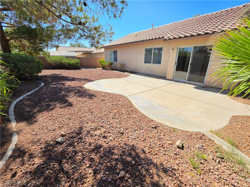1154 Point Success Avenue Henderson, NV 89014 - Photo 22 of 26 A spacious backyard with a tiled patio and rock landscaping awaits outdoor enjoyment.