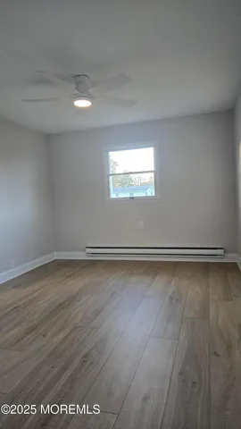 a view of a room with wooden floor and window