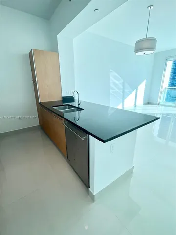 a kitchen with kitchen island cabinets and sink