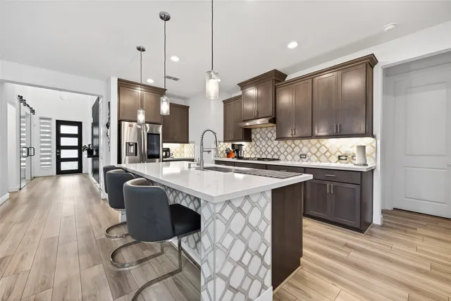 a kitchen with stainless steel appliances granite countertop a sink a stove and a refrigerator