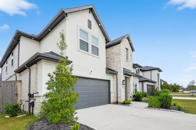 a front view of a house with a garden and plants