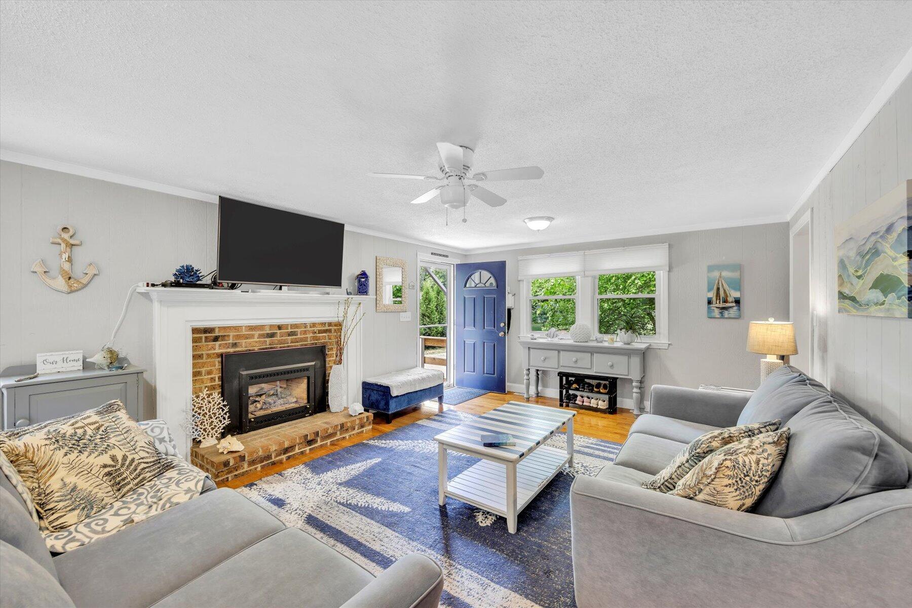 30 Guildford Road Centerville, MA 02632 - Photo 11 of 42 a living room with furniture a fireplace and a flat screen tv