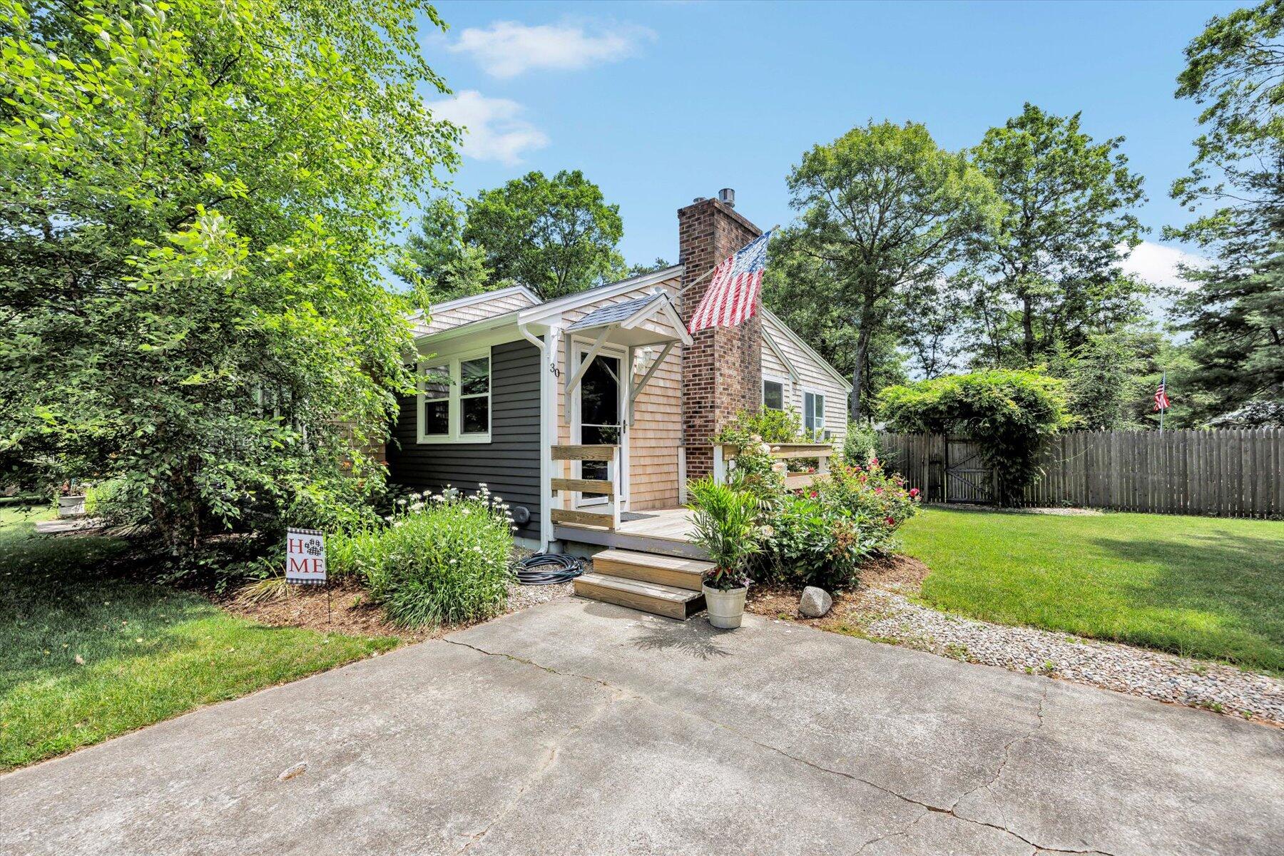 30 Guildford Road Centerville, MA 02632 - Photo 4 of 42 a front view of a house with a yard and potted plants