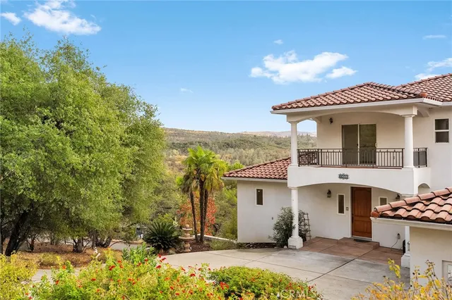 a view of a livingroom with a chandelier fan and wooden floor