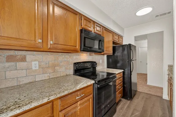 a view of kitchen with stainless steel appliances granite countertop cabinets and a counter top space
