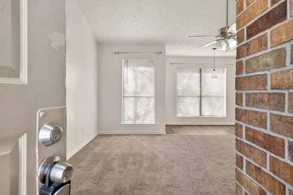 a view of a room with a ceiling fan and window