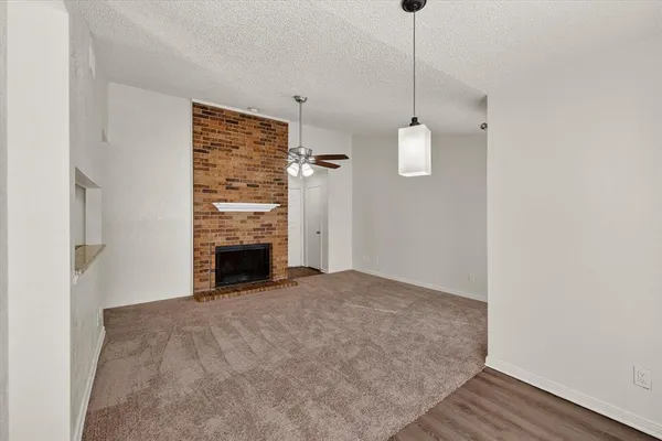 a view of empty room with wooden floor and fireplace