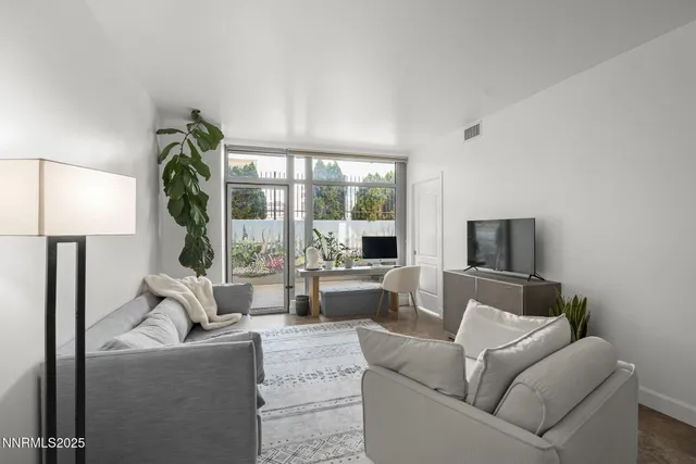 a living room with furniture a large window and a flat screen tv